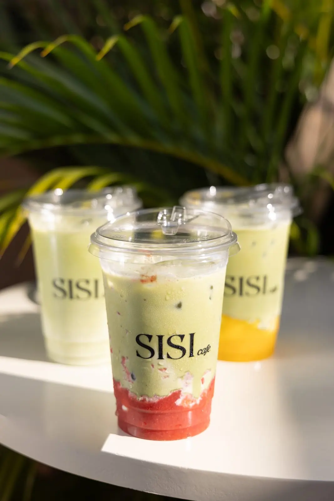 Two strawberry matcha drinks in the sun